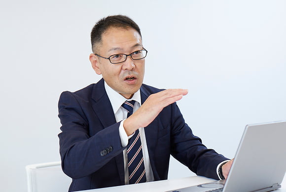 写真：記者の取材に答える武田 忠