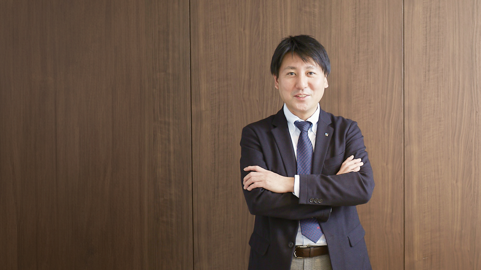 写真:腕を組んで立っている大塚浩之