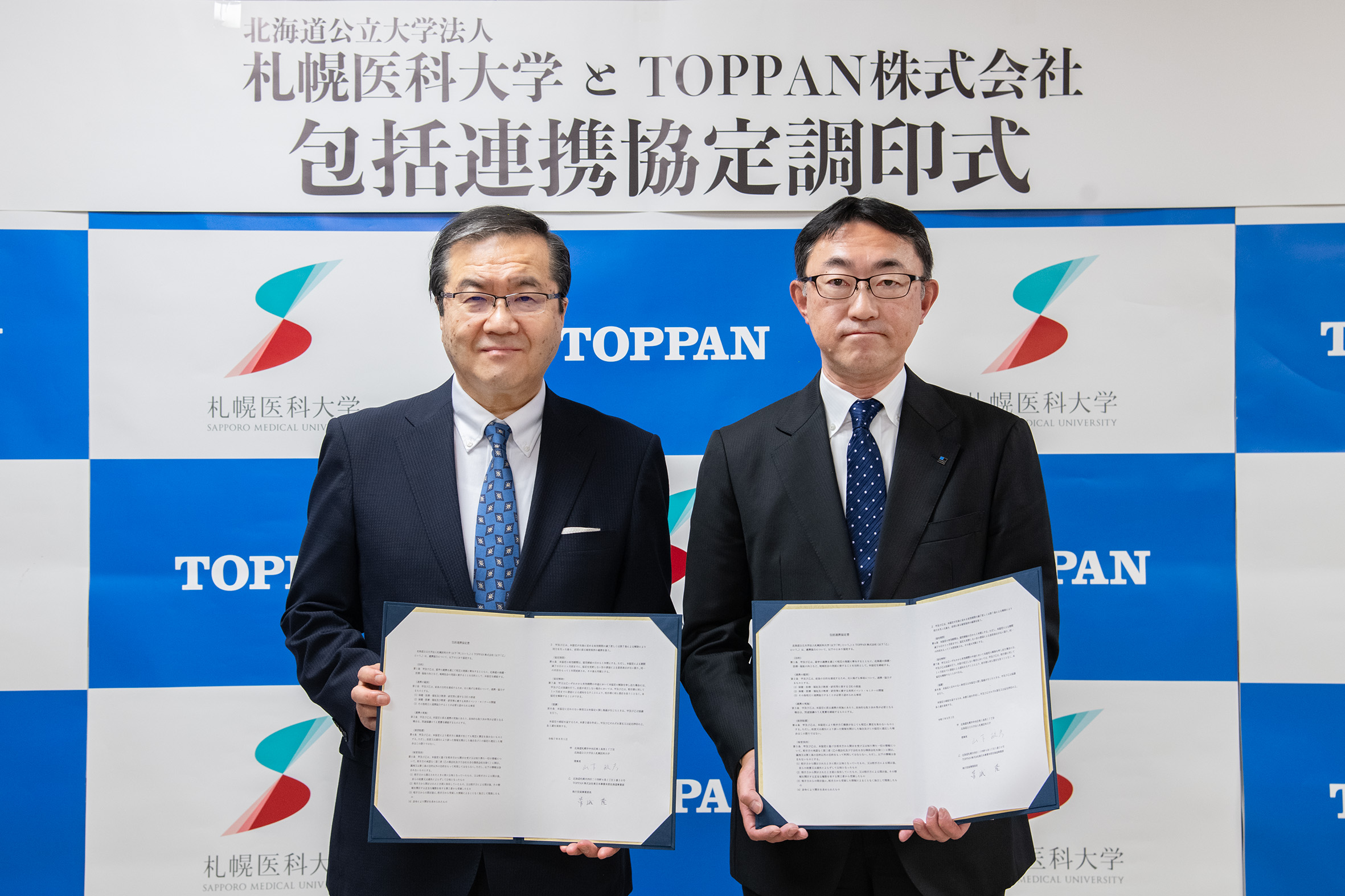 包括連携協定 締結式の様子 (左)札幌医大理事長・学長 山下 敏彦、(右)TOPPAN 東日本事業本部北海道事業部長 菅峨 隆
