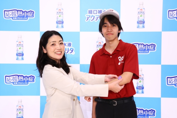 「示温シール」配布の様子 左：株式会社ファンケル 経営企画本部 新規事業推進部 松田 右：早稲田実業学校高等部 吹奏楽部　部長 永井さん