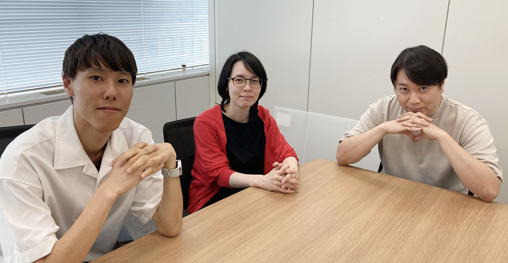 男性社員2名と女性社員2名が正面を向いて並んで座っている様子