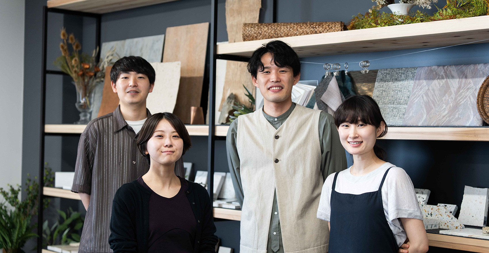 男性社員2名と女性社員2名が正面を向いて並んで微笑んでいる様子