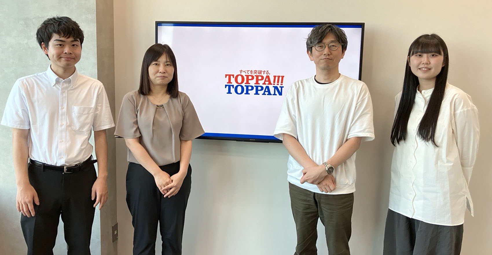 男性社員2名と女性社員2名が正面を向いて並んで立っている様子