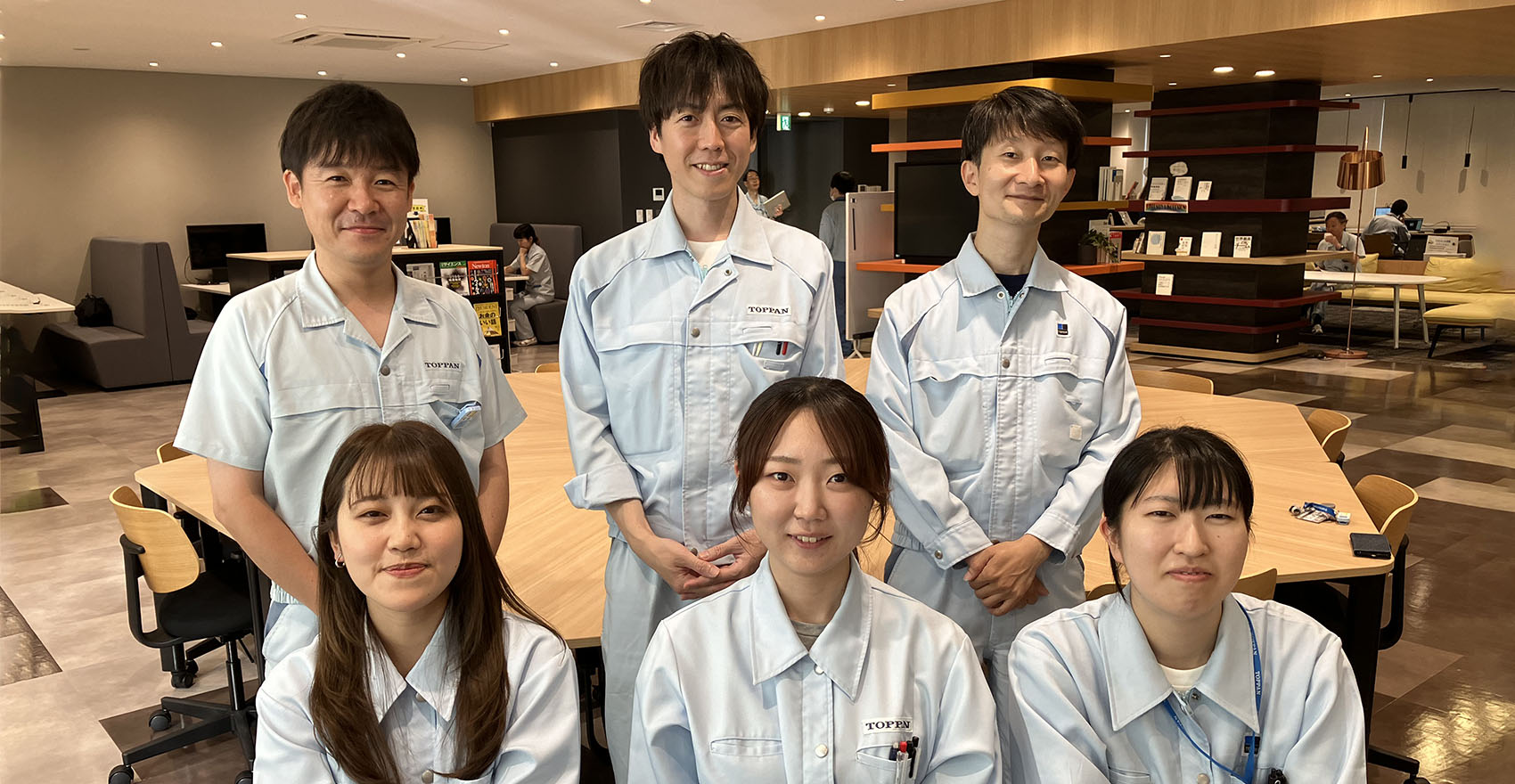 青い作業服を着た人々のグループ